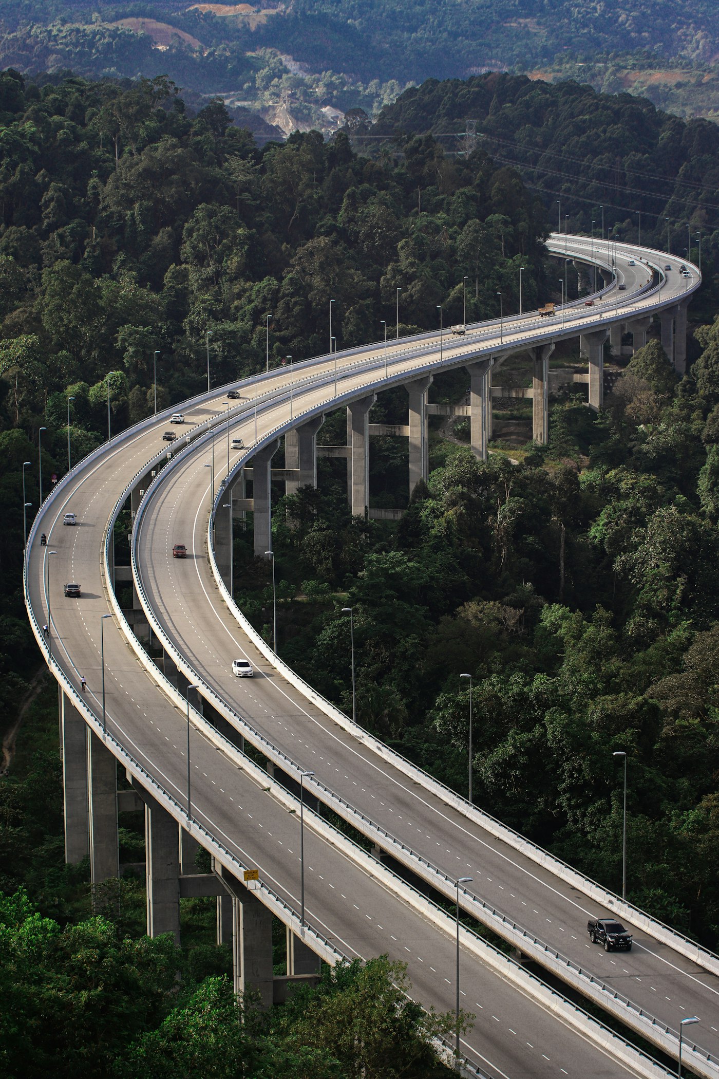 Aerial view of a divided highway through a forest